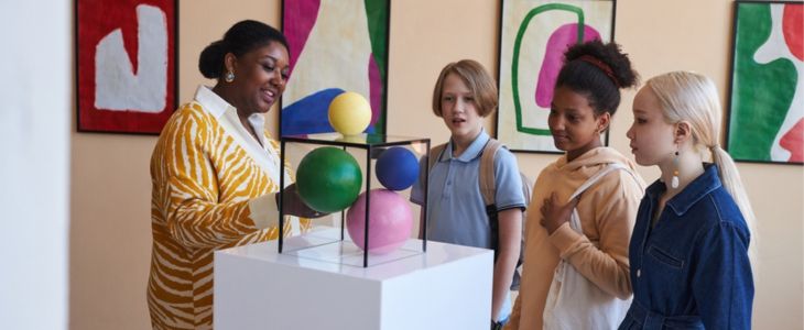 A group of children with a chaperone at a museum