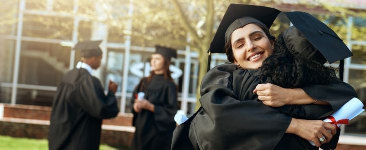 Graduates hug after a graduation ceremony