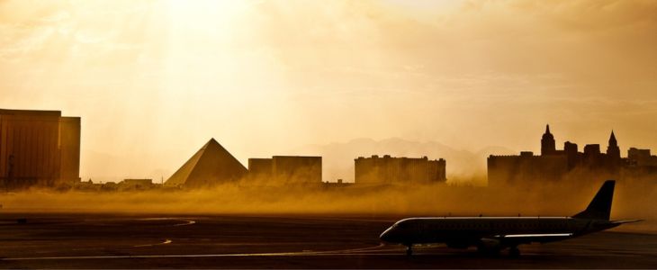 a plane on a runway in front of the las vegas skyline