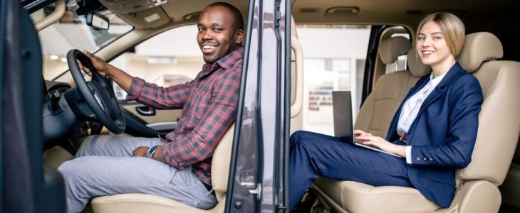 a corporate employee sits in a shuttle behind a bus driver