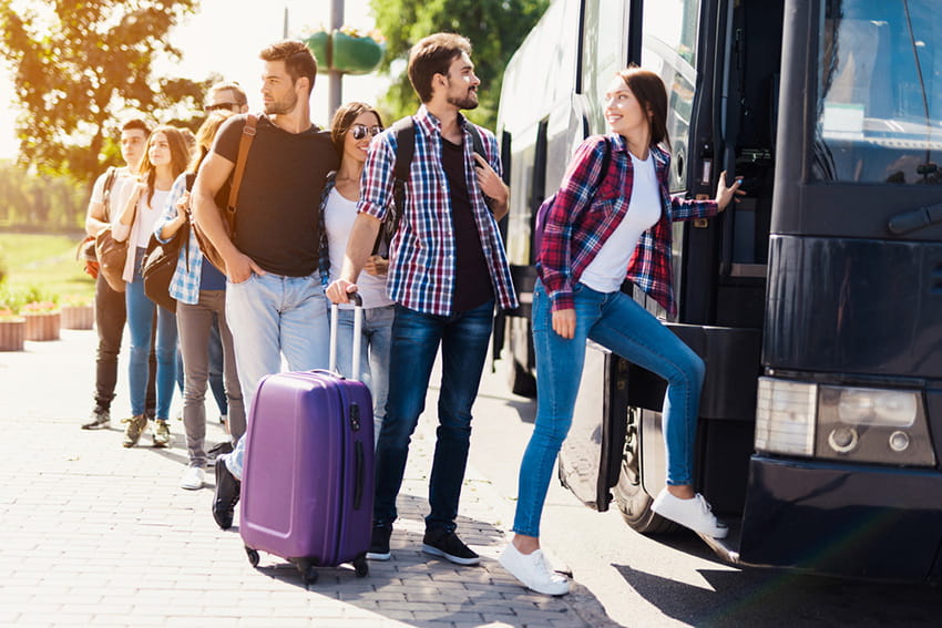 a group of tourists board a charter bus rental