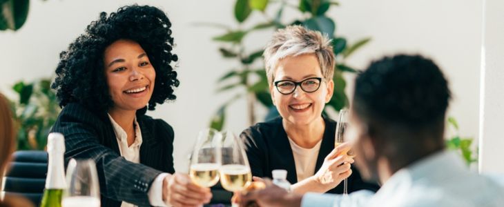 a couple of women sipping wine at a corporate lunch