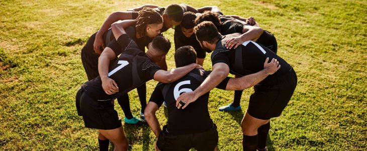 A football team huddling at a practice.