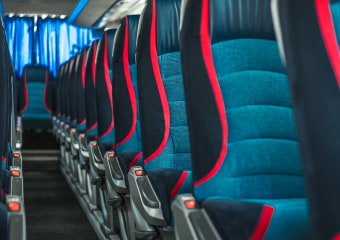 Interior of a bus rental with a passenger sitting in a seat facing away